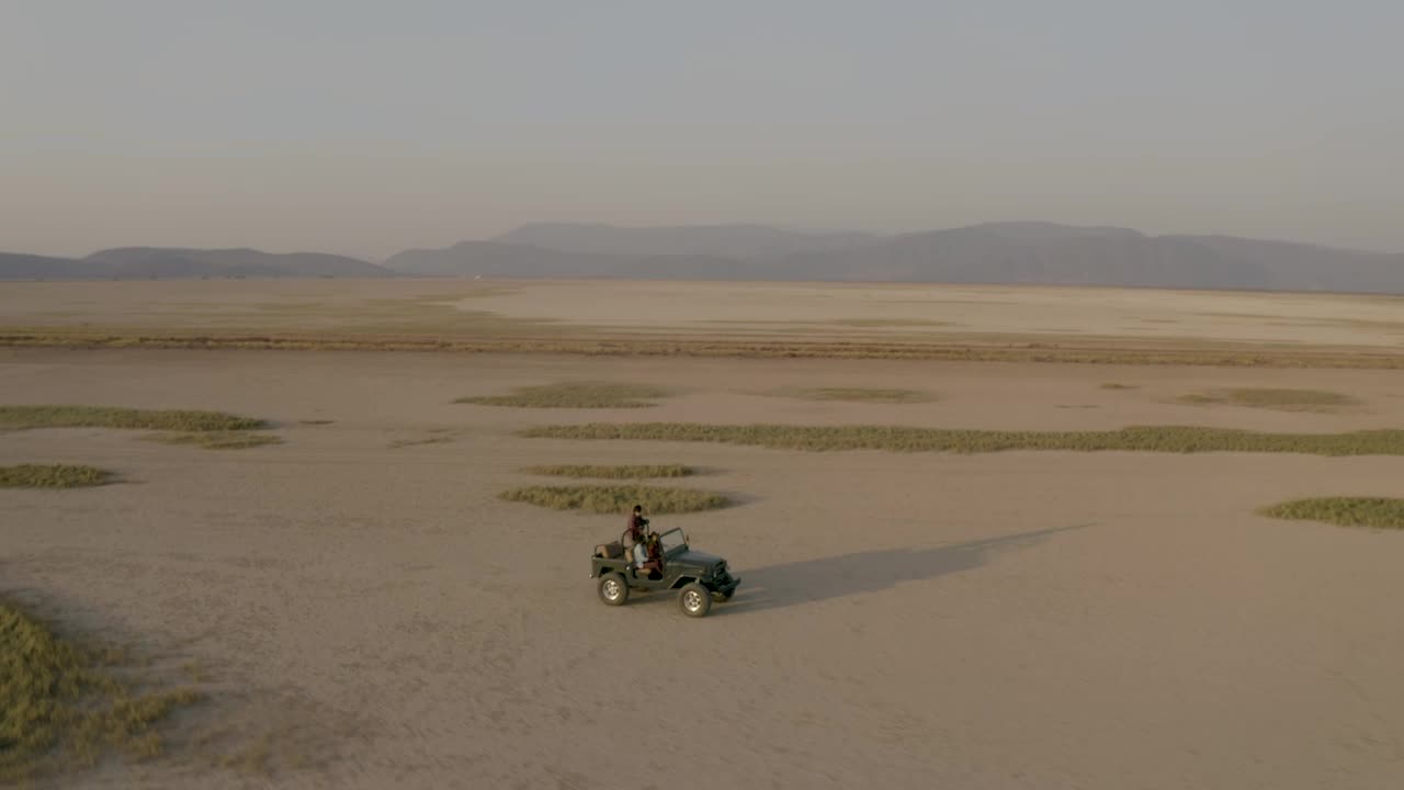 Download Stock Video Aerial Shot Of A Jeep Truck Traveling Through A Desert Live Wallpaper for PC