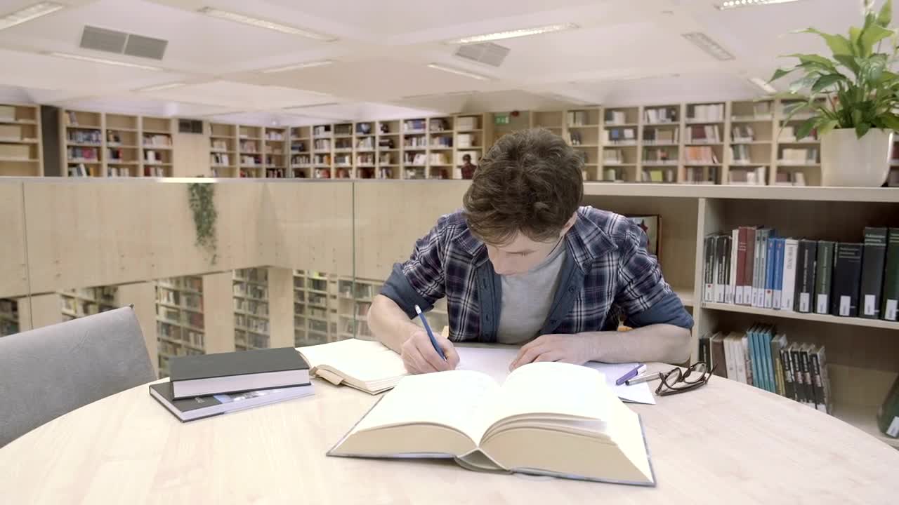 Download Stock Video A Young Man Studying In The Library Live Wallpaper For PC