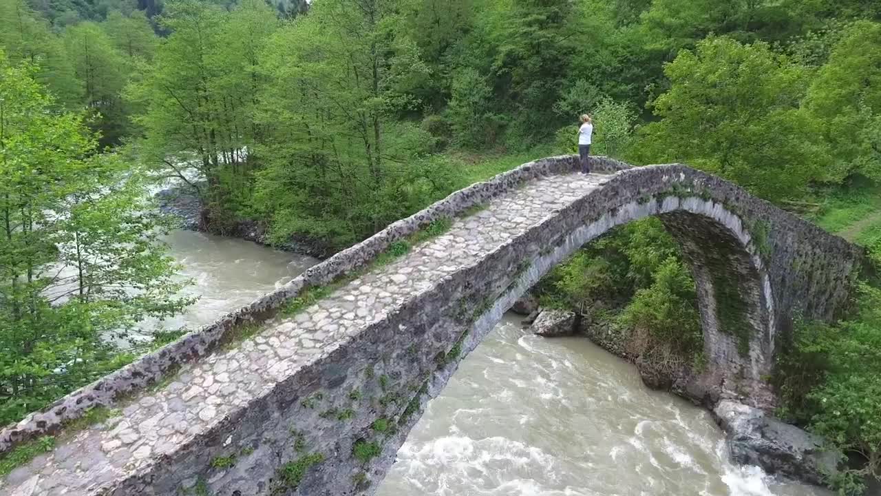 Download Stock Video A Woman Standing In An Old Stone Bridge Above The Live Wallpaper For PC