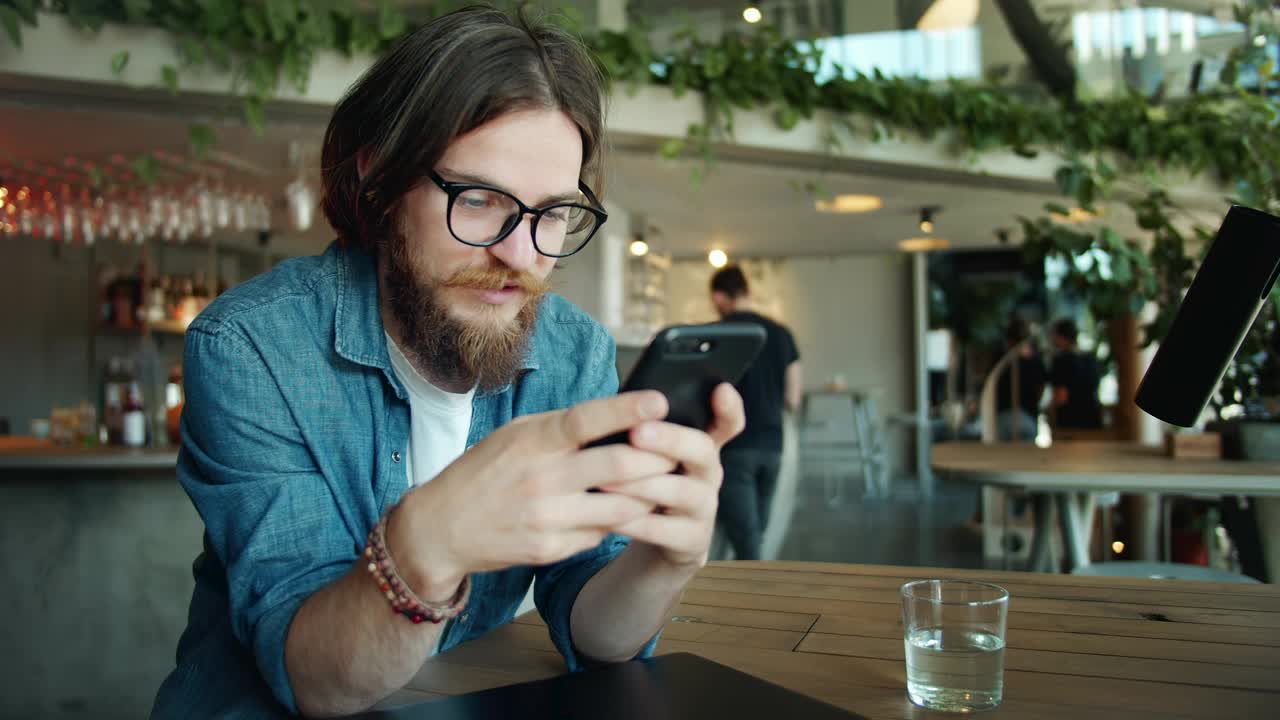 Download Stock Video Bearded Man Using Mobile App In Airport Cafe Live Wallpaper For PC