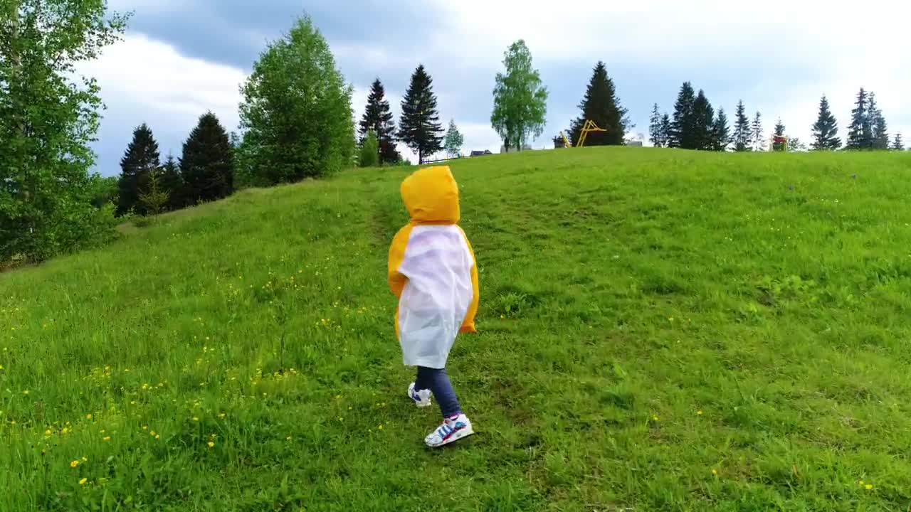 Download Video Stock Child Taking A Walk In The Grass Wearing A Raincoat Live Wallpaper For PC