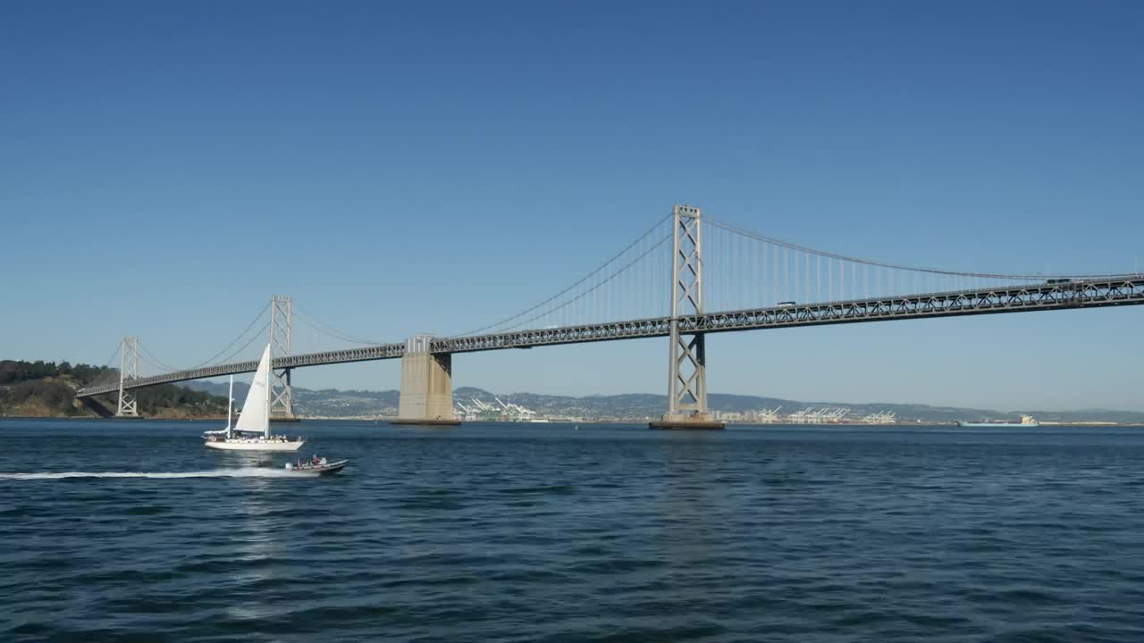 Download Video Stock Cargo Ship And Sailboat Crossing Under The Bridge Live Wallpaper For PC