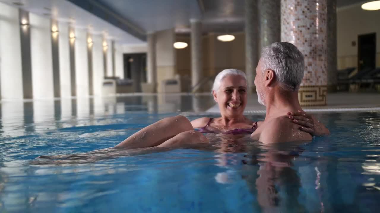 Download Stock Video Elderly Couple Enjoying Time In The Pool Live Wallpaper For PC