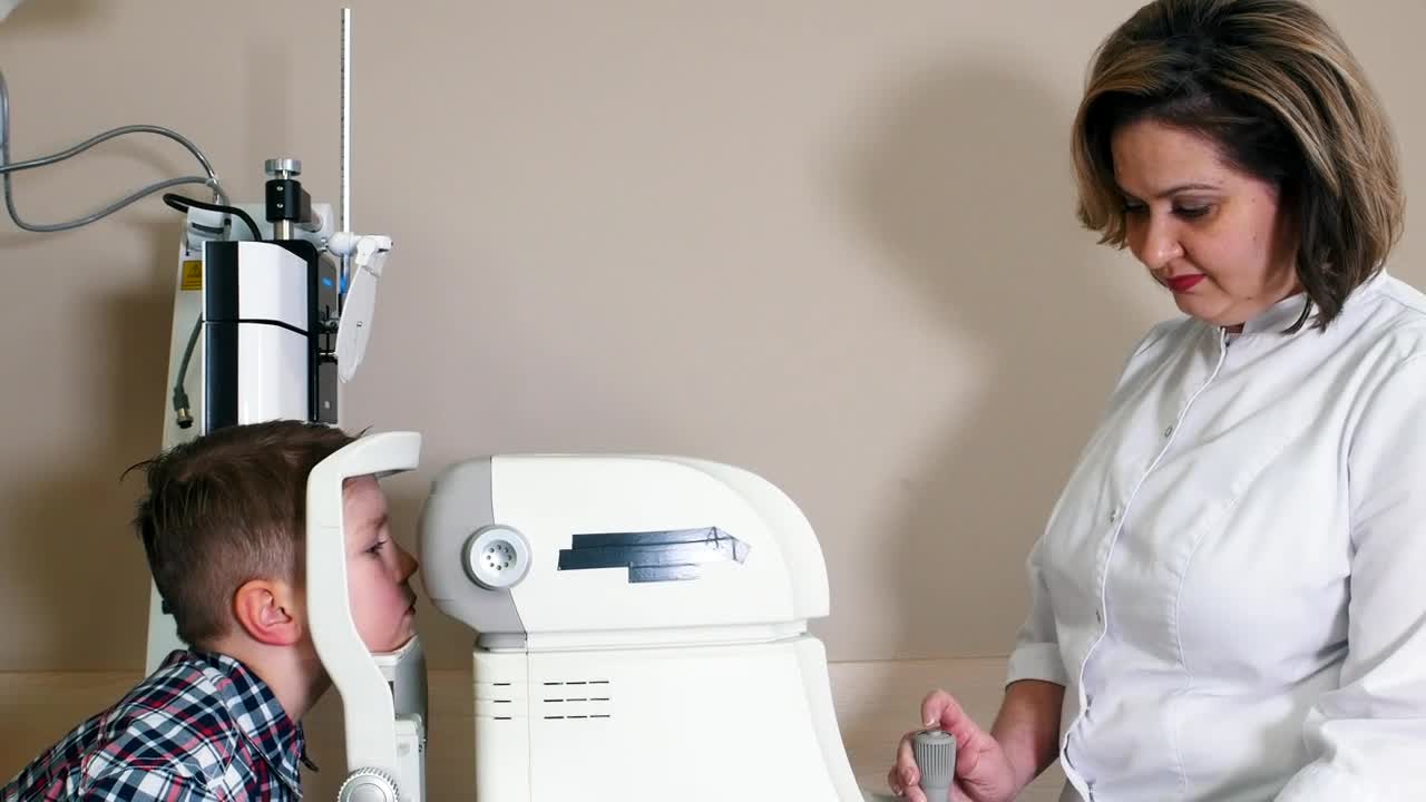 Download Stock Video Female Ophthalmologist Doing An Eye Exam To A Child Live Wallpaper For PC