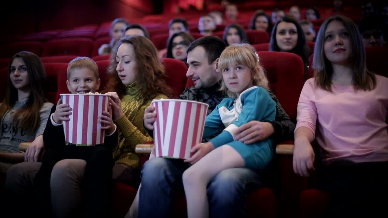 Download Stock Video Family Enjoying A Movie At The Cinema Medium Shot Live Wallpaper For PC