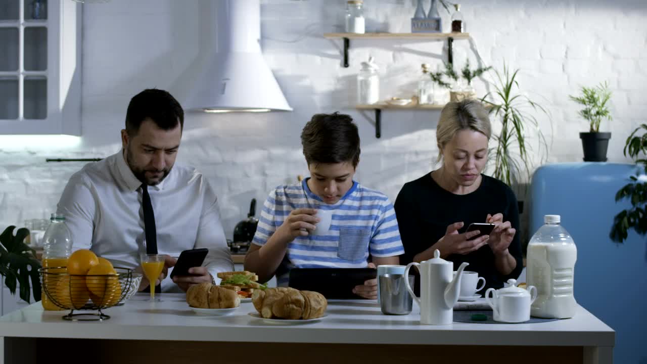 Download Stock Video Family At Breakfast Watching Their Smartphones Live Wallpaper For PC