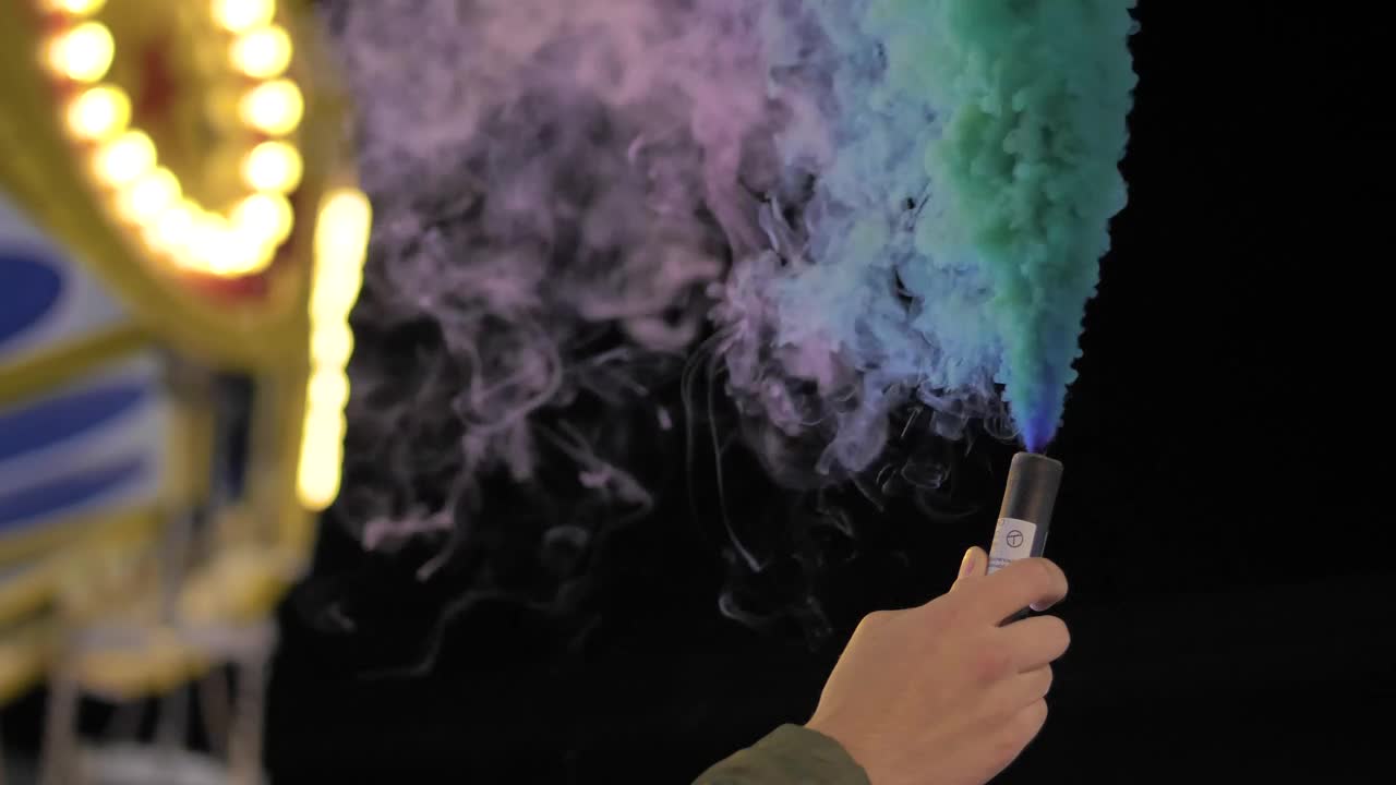 Download Stock Video Hand Holding A Multicolored Smoke Bomb At The Fair Live Wallpaper For PC