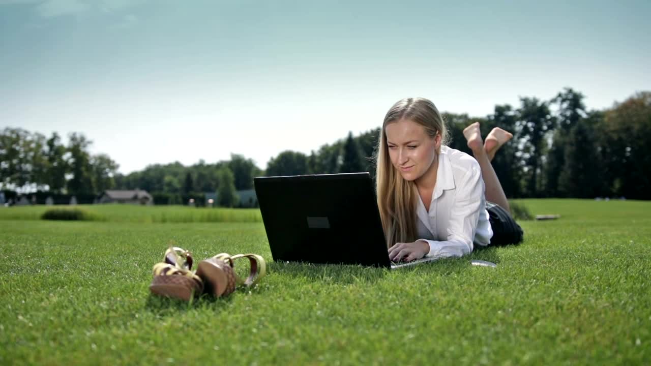 Download Stock Video Girl Lying On The Grass Working On Her Computer Live Wallpaper For PC