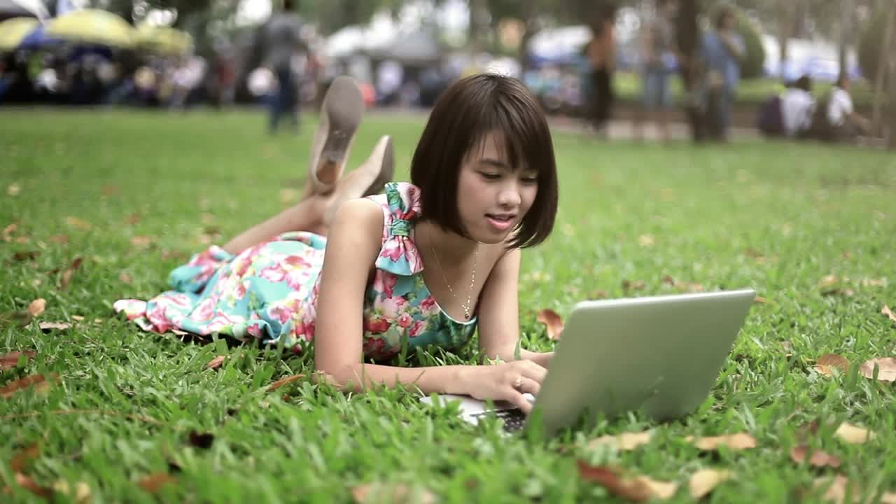 Download Stock Video Girl Lying In A Park With A Computer Live Wallpaper For PC