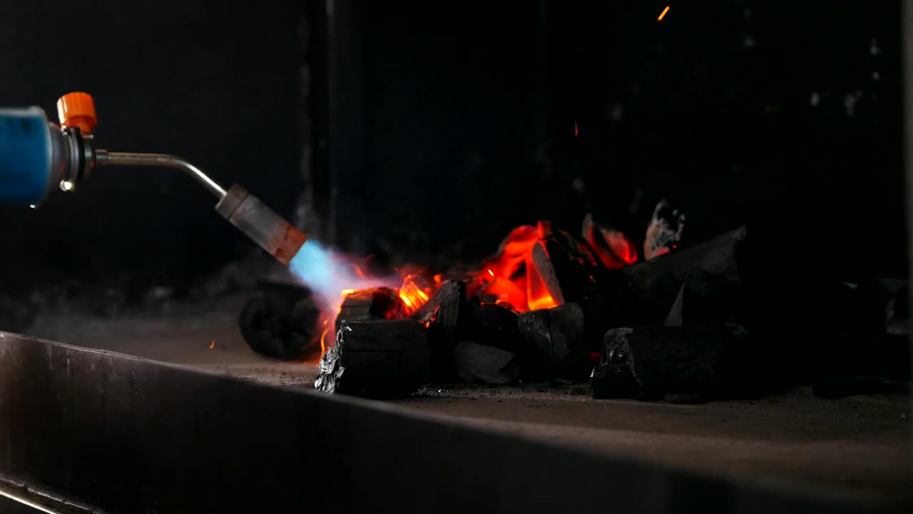 Download Stock Video Kindling Charcoal For The Grill With A Gas Burner Animated Wallpaper