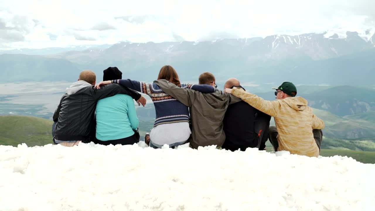 Download Stock Video Hugging Friends Look At Mountain Landscape From Snowy Ridge Animated Wallpaper