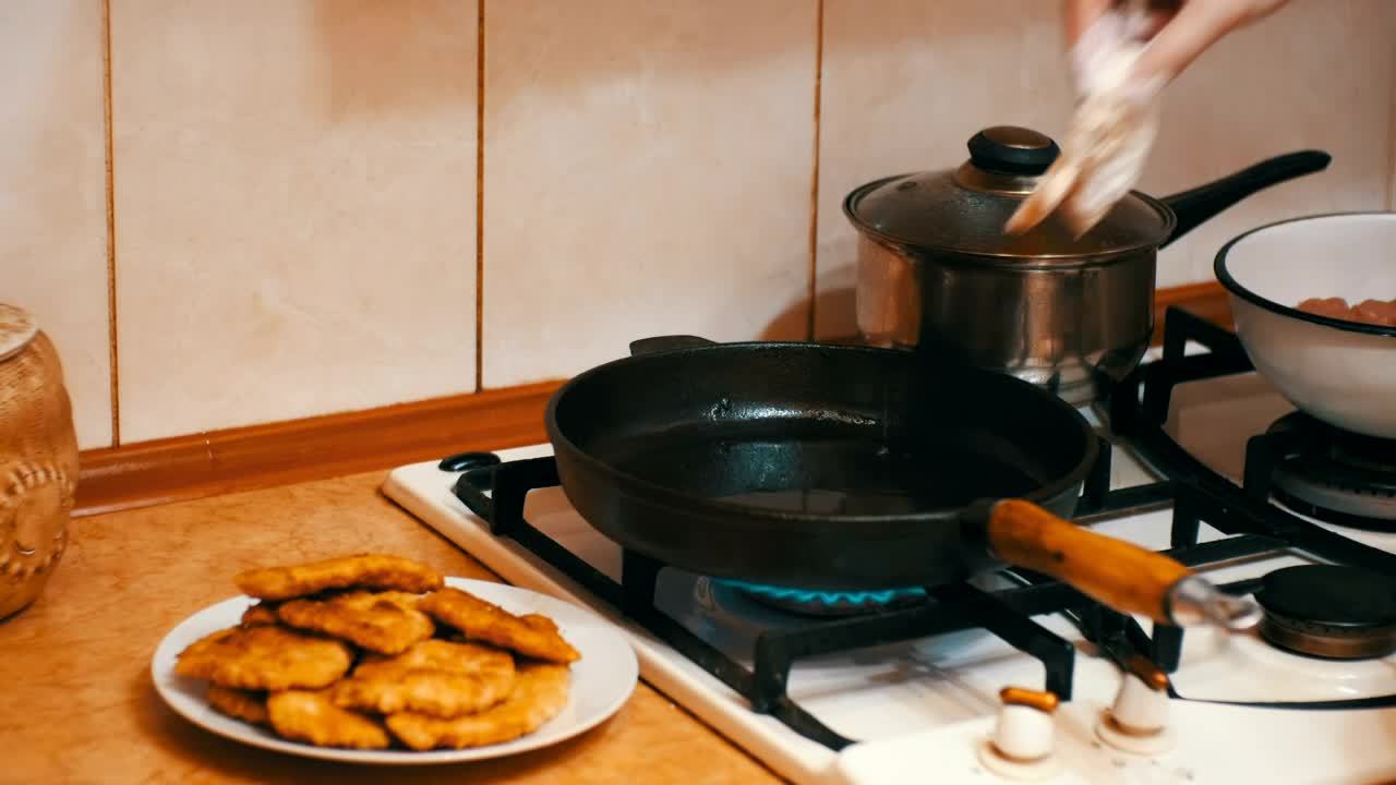 Download Stock Video Housewife Frying Meat In A Frying Pan Animated Wallpaper