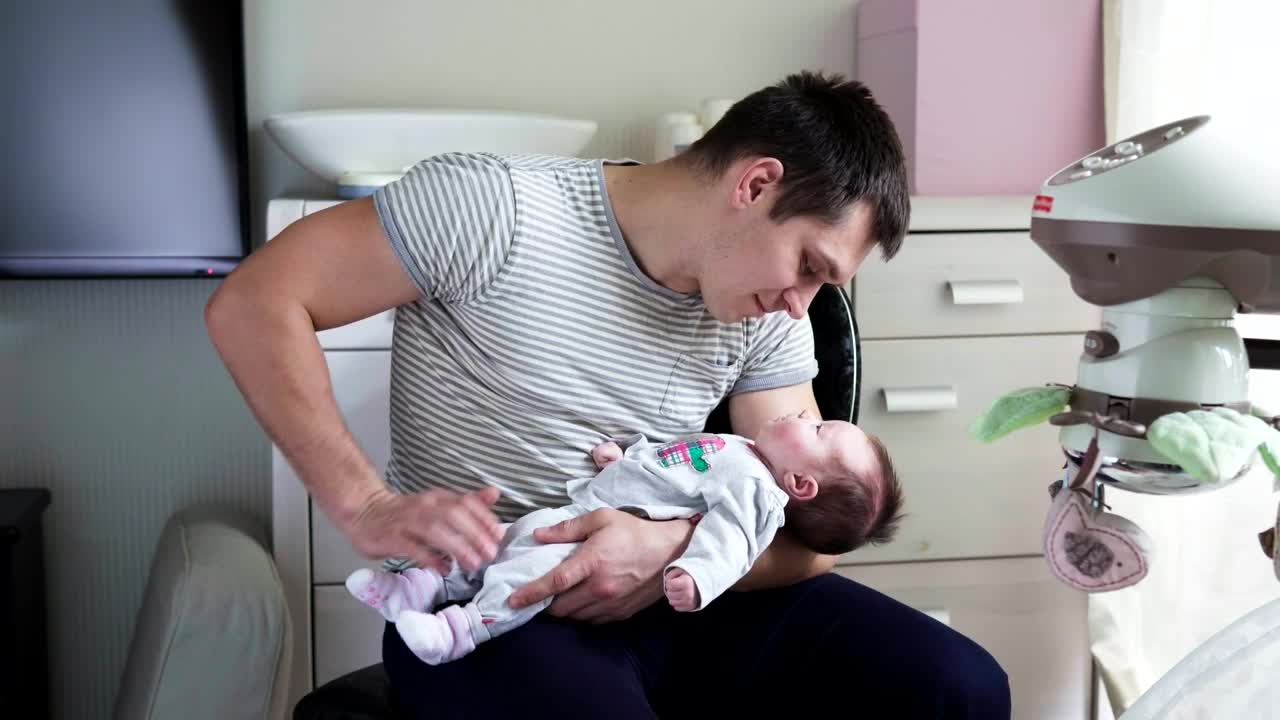 Download Stock Video Holding His Newborn Child In His Arms Animated Wallpaper