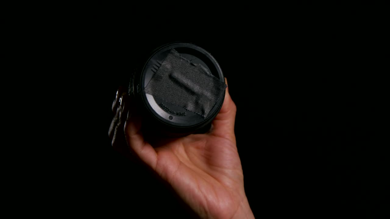 Download Stock Video Holding A Camera Lens Cap Animated Wallpaper