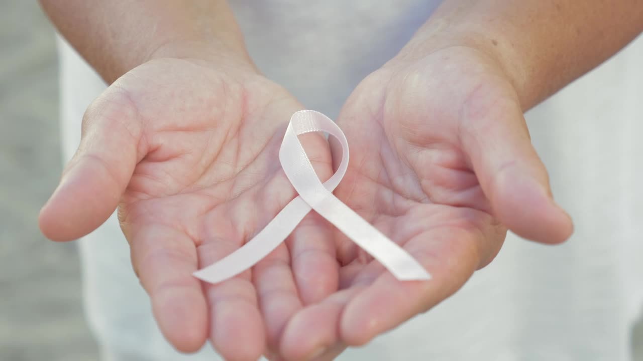 Download Stock Video Holding A Breast Cancer Ribbon In Her Hands Animated Wallpaper