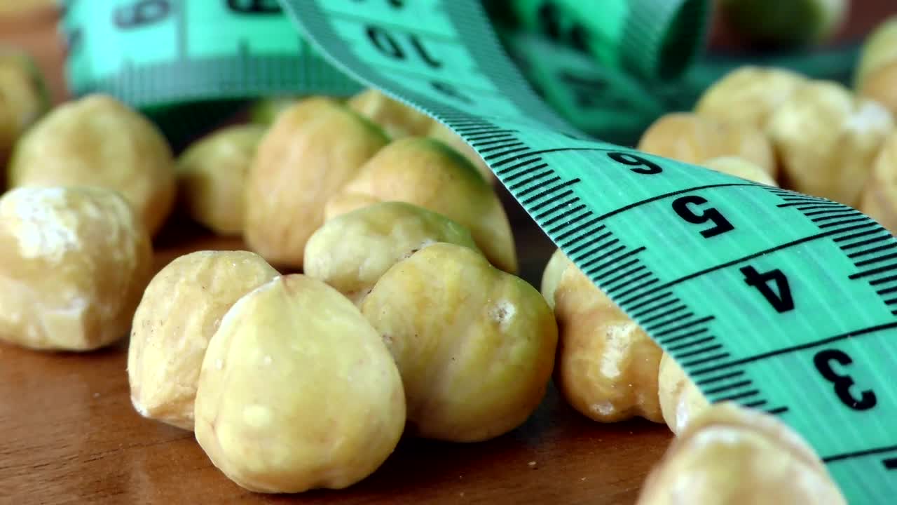 Download Stock Video Hazelnuts And Measuring Tape Macro Animated Wallpaper