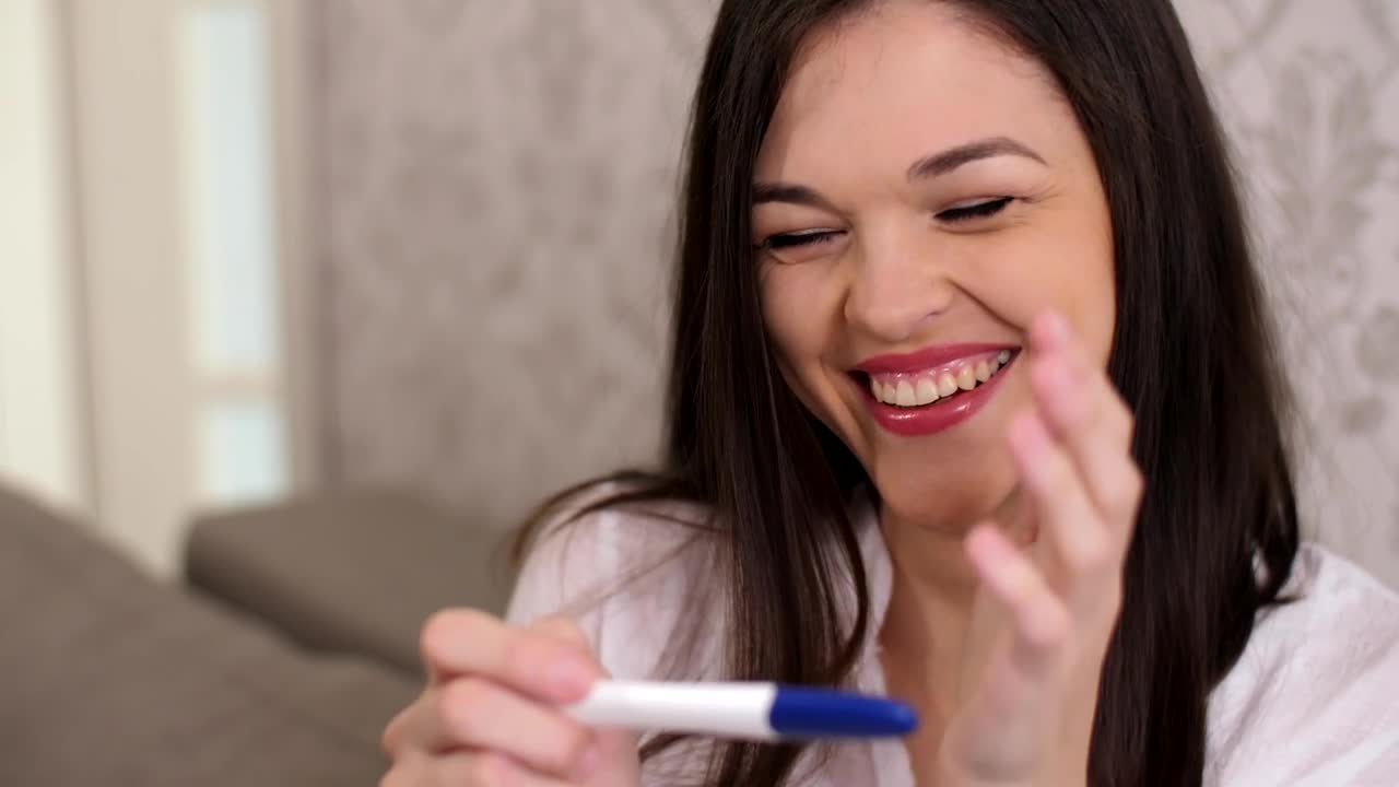 Download Stock Video Happy Woman Smiles When Checking That She Is Pregnant Animated Wallpaper