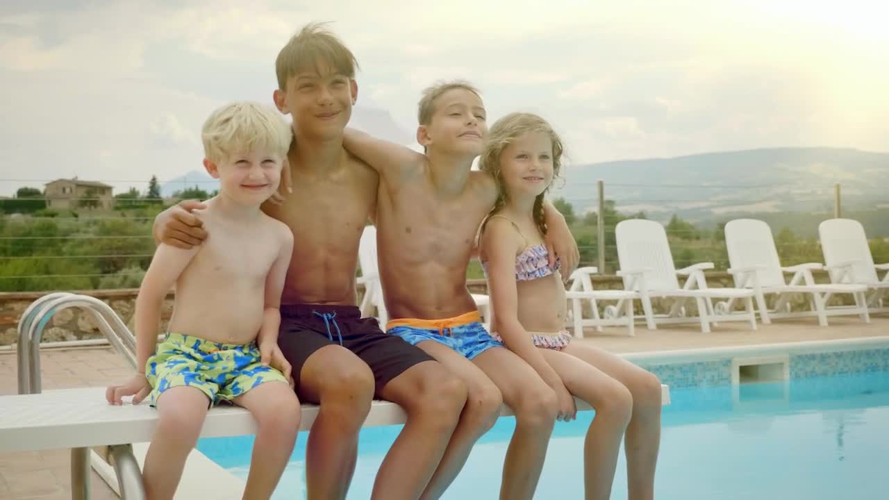 Download Stock Video Happy Kids Sit On Diving Board Of Pool Posing For Animated Wallpaper