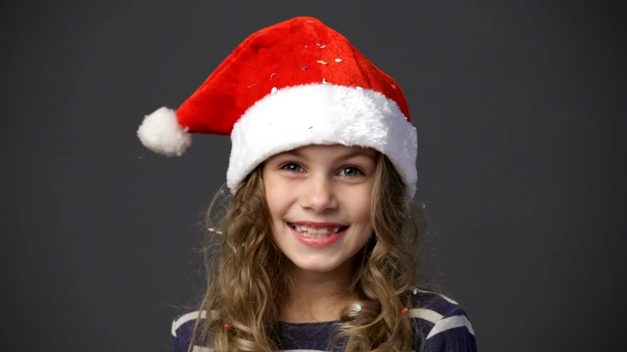 Download Stock Video Happy Girl Wearing A Christmas Hat Animated Wallpaper