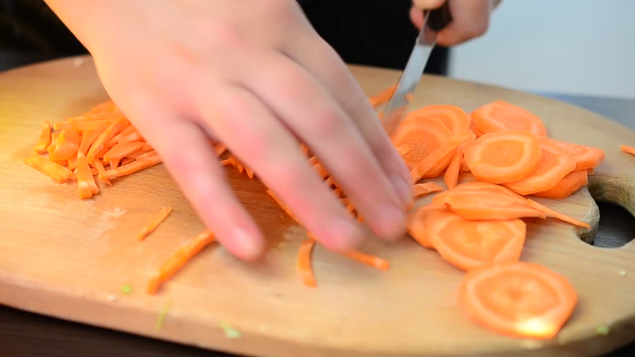 Download Stock Video Hands Of A Person Chopping Carrots On A Board Animated Wallpaper