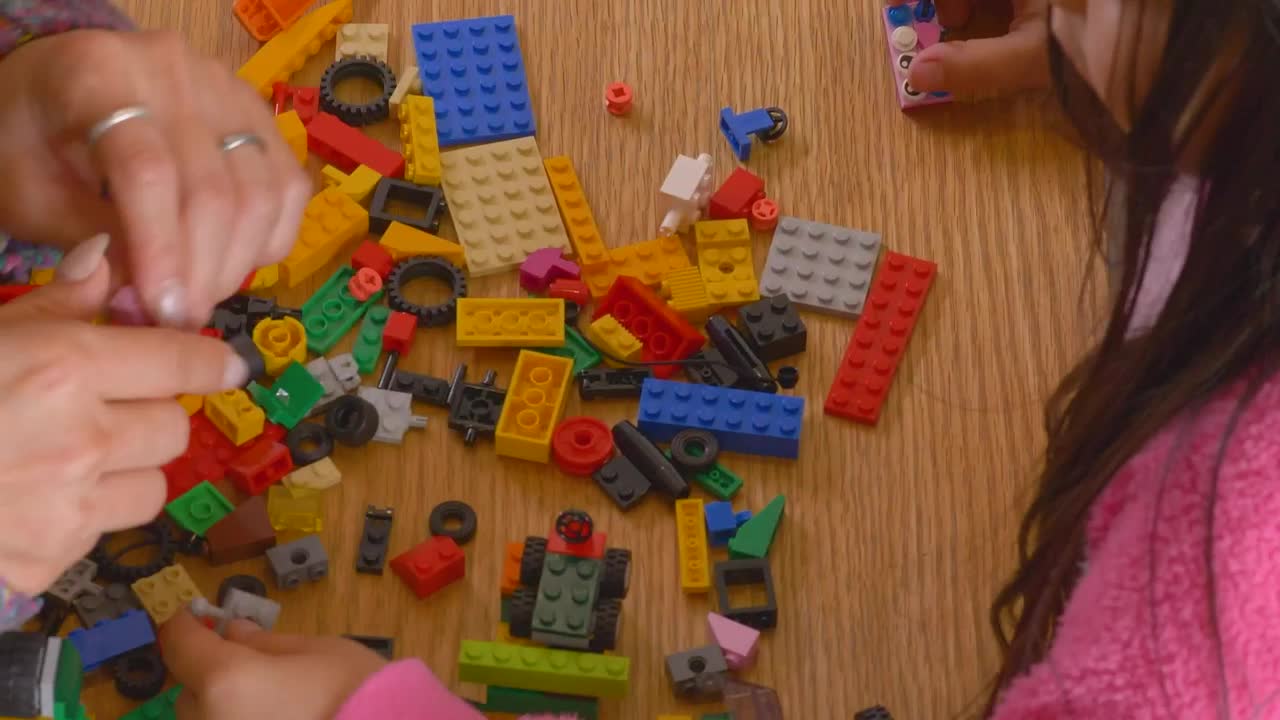 Download Stock Video Hands Of A Mother And Daughter Playing With Legos Animated Wallpaper