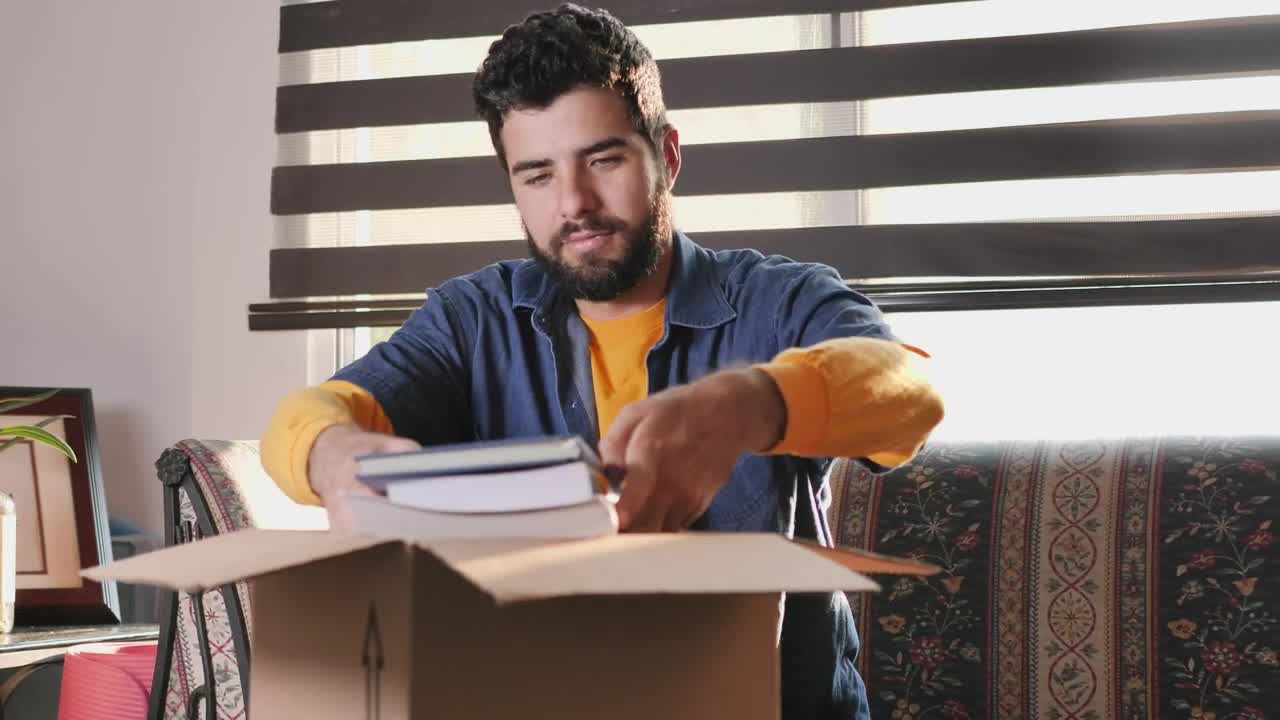 Download Stock Video Man In His Living Room Finishes Packing A Box To Animated Wallpaper