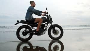 Download Stock Video Man In Denim Jacket Riding Motorcycle On Beach Animated Wallpaper