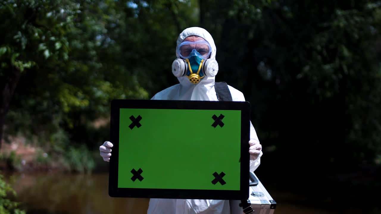 Download Stock Video Man In Biohazard Suit Holding A Greenscreen Sign Animated Wallpaper