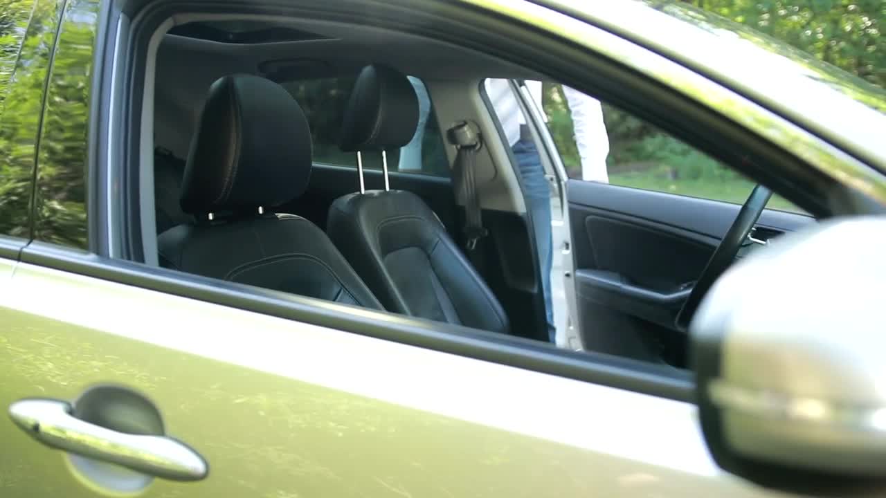 Download Stock Video Man Getting Into A Car And Putting On A Seat Animated Wallpaper