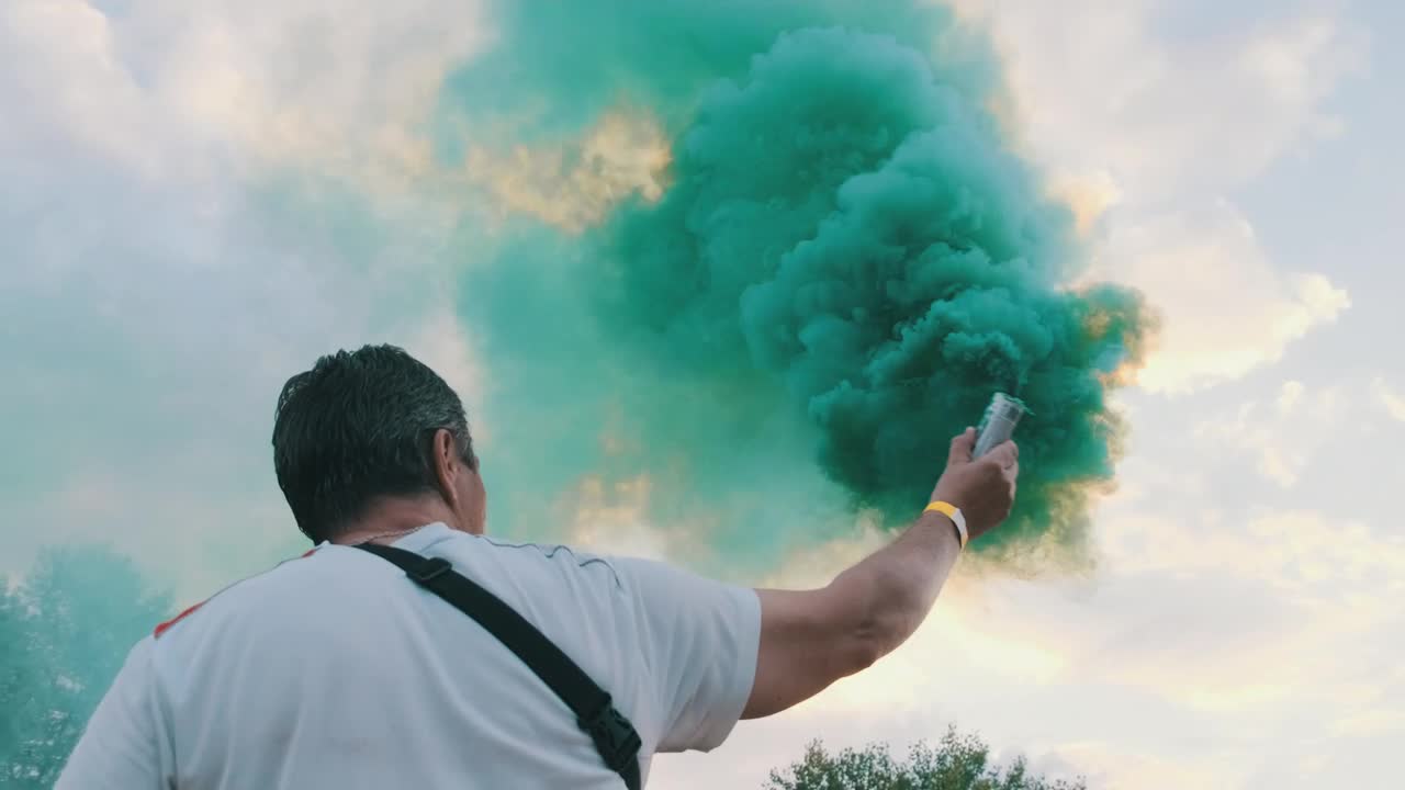 Download Stock Video Man From Behind Waving A Smoke Bomb Animated Wallpaper