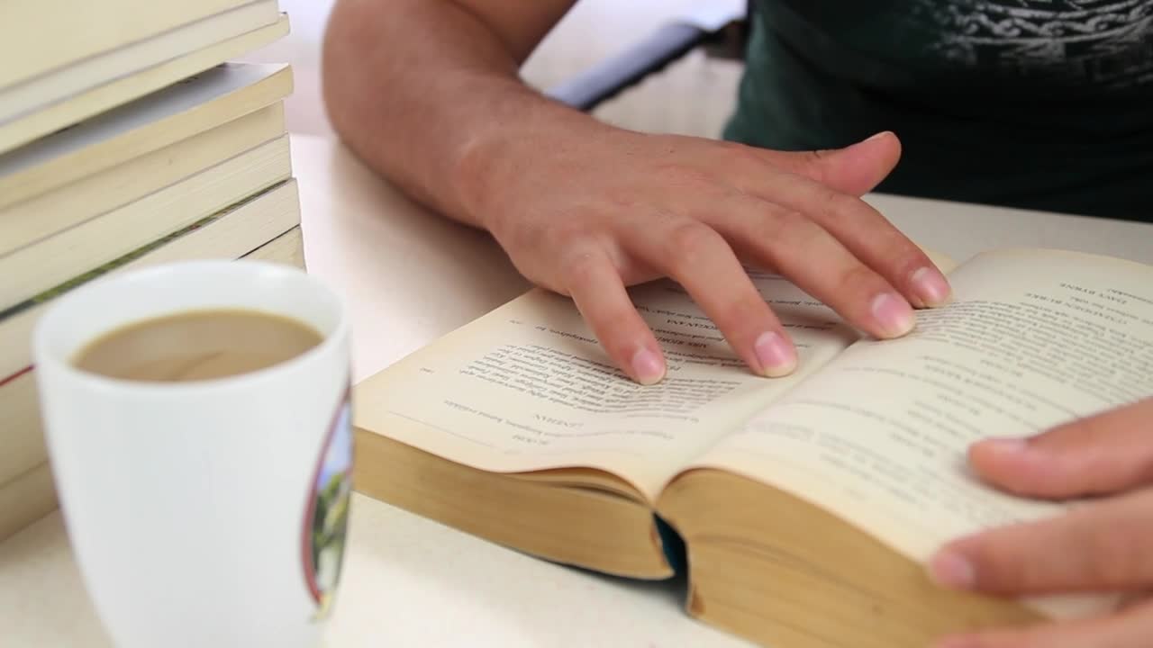 Download Stock Video Man Drinks Coffee From A Mug While Studying Animated Wallpaper