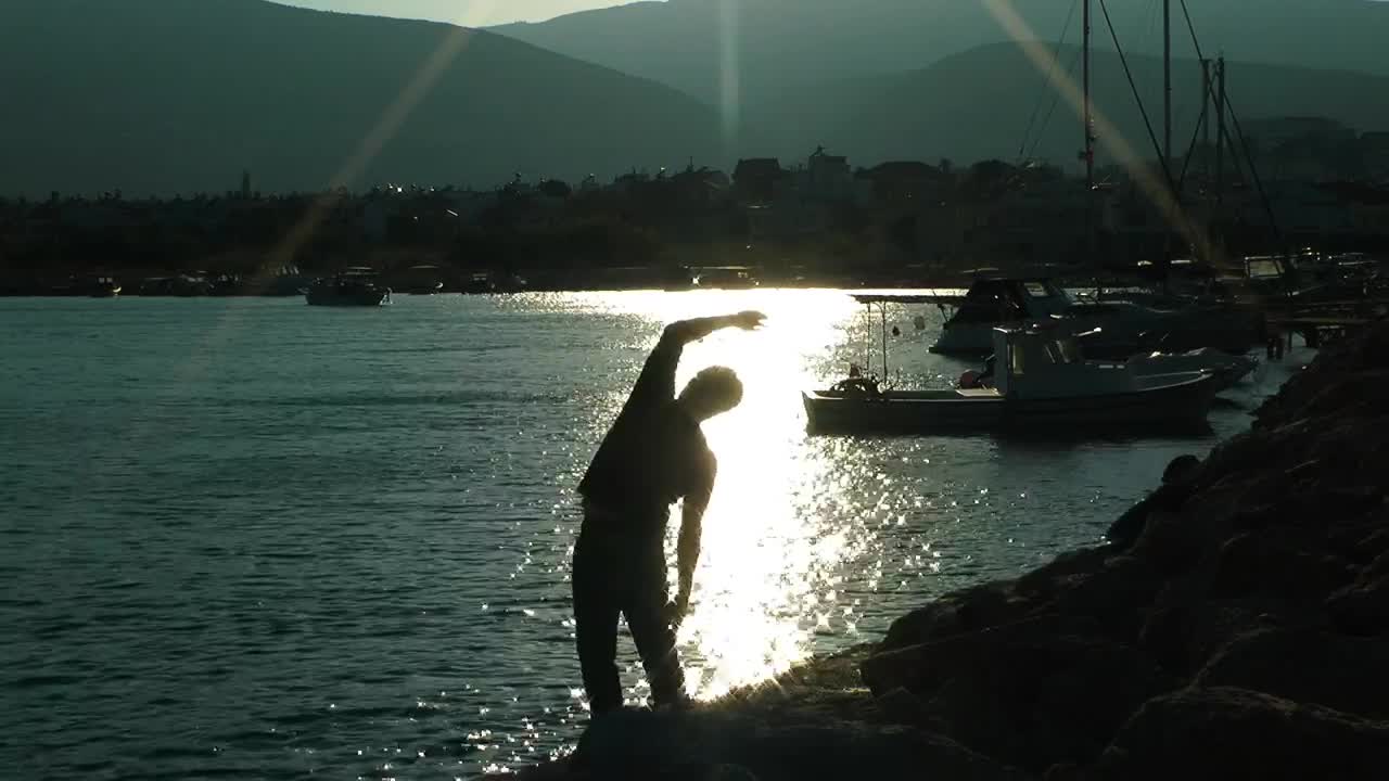 Download Stock Video Man Doing Stretching In Port At Sunrise Animated Wallpaper