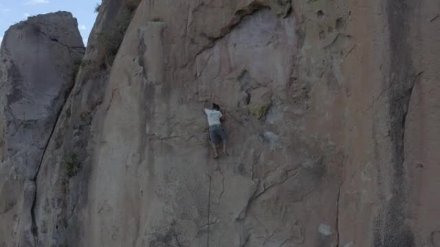 Download Stock Video Man Doing Mountaineering On A Large Rocky Mountain Smal Animated Wallpaper