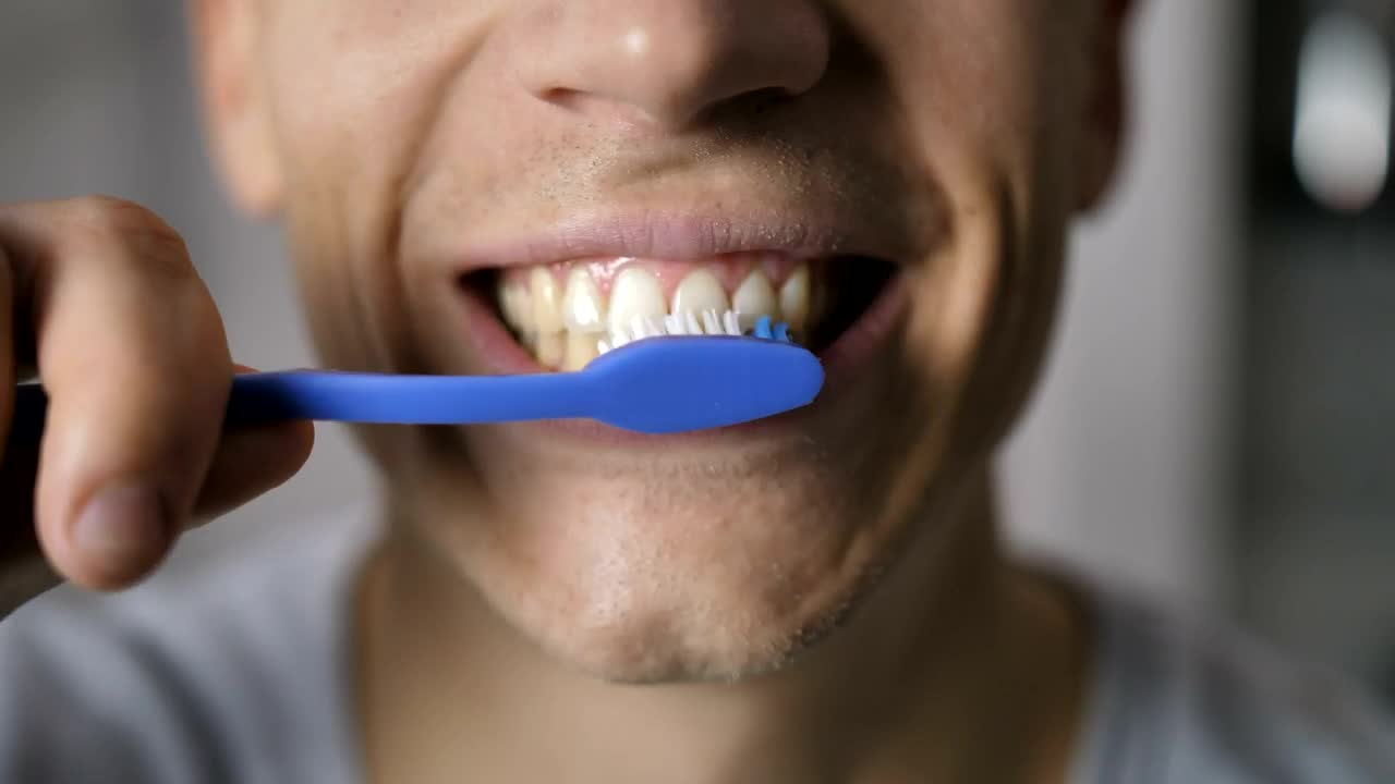 Download Stock Video Man Brushing His Teeth In A Very Close Shot Animated Wallpaper