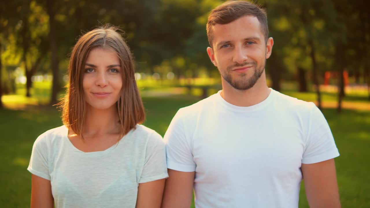 Download Stock Video Man And Woman Smiling Head On In A Park Animated Wallpaper