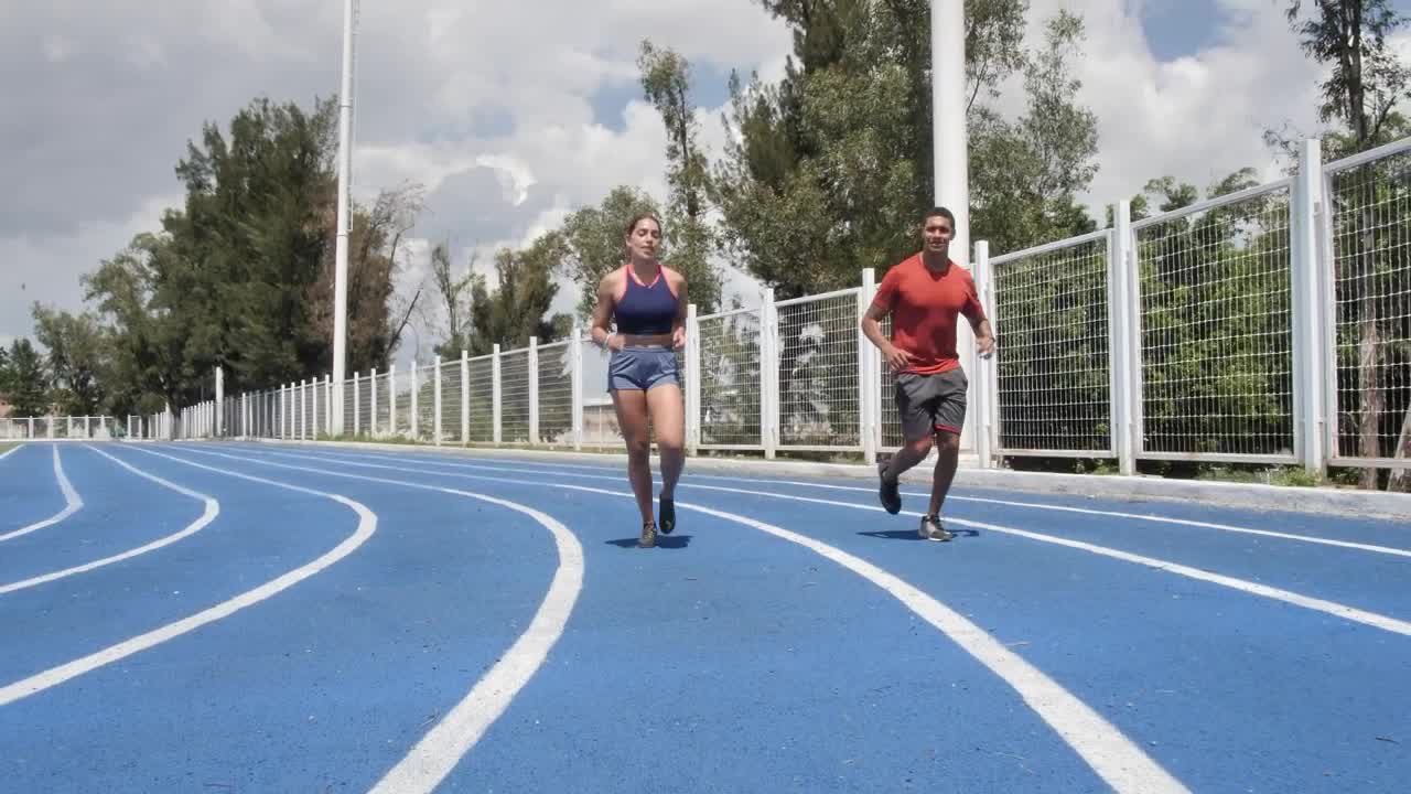 Download Stock Video Man And Woman Jogging On A Running Track Animated Wallpaper