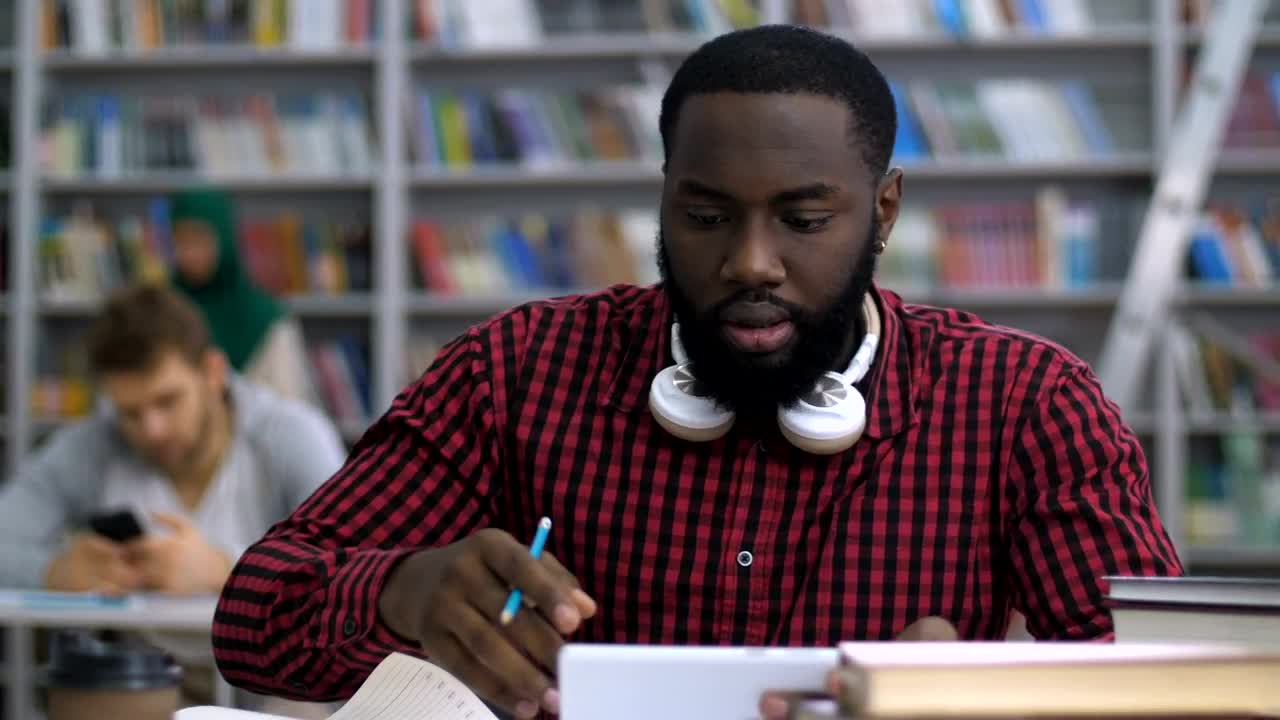 Download Stock Video Male Student Reading In The Library Animated Wallpaper