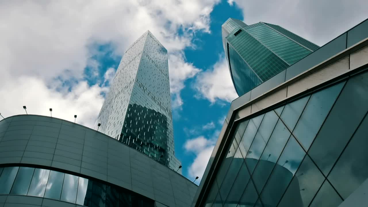 Download Stock Video Low View Of Office Buildings With Clouds In The Sky Animated Wallpaper