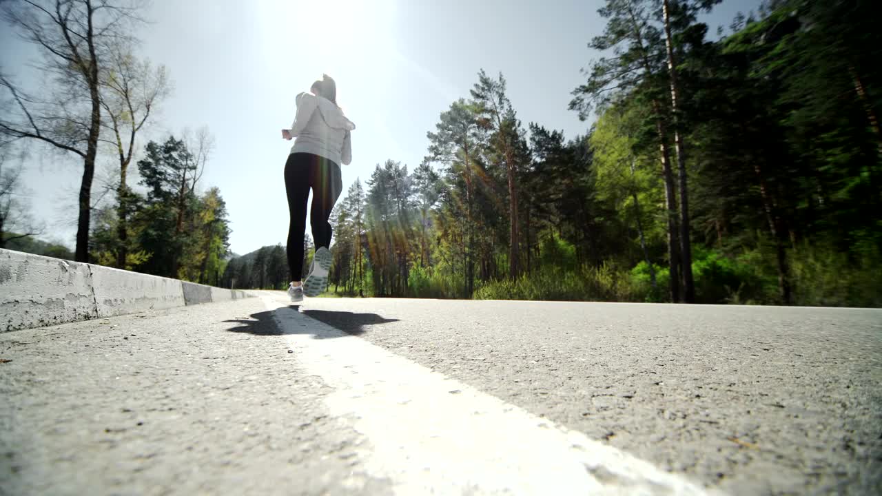 Download Stock Video Low Angle Of Runner Jogging On Forest Road Animated Wallpaper