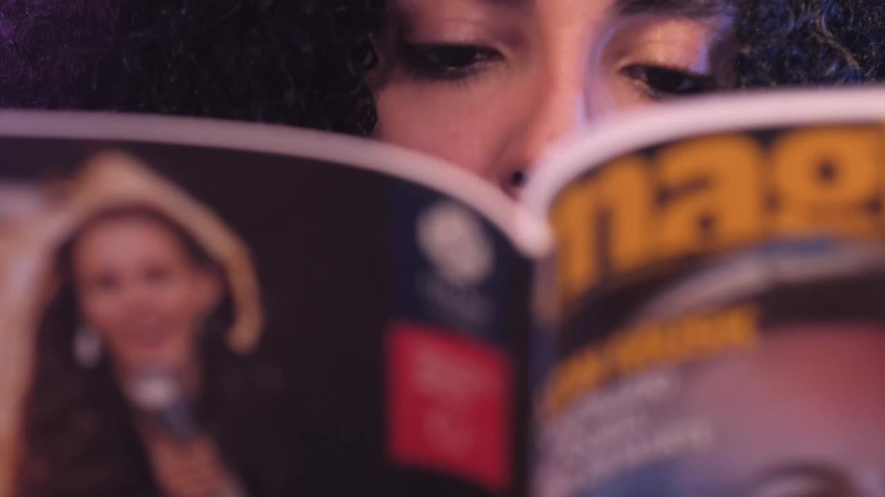 Download Stock Video Look Of A Girl While She Reads A Magazine Animated Wallpaper