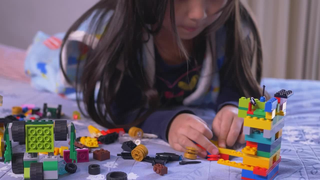 Download Stock Video Little Girl Playing On Her Bed With Legos Animated Wallpaper