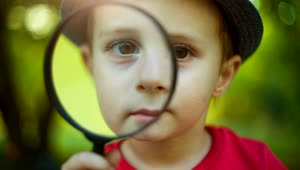 Download Stock Video Little Boy Looking Through A Magnifying Glass Animated Wallpaper