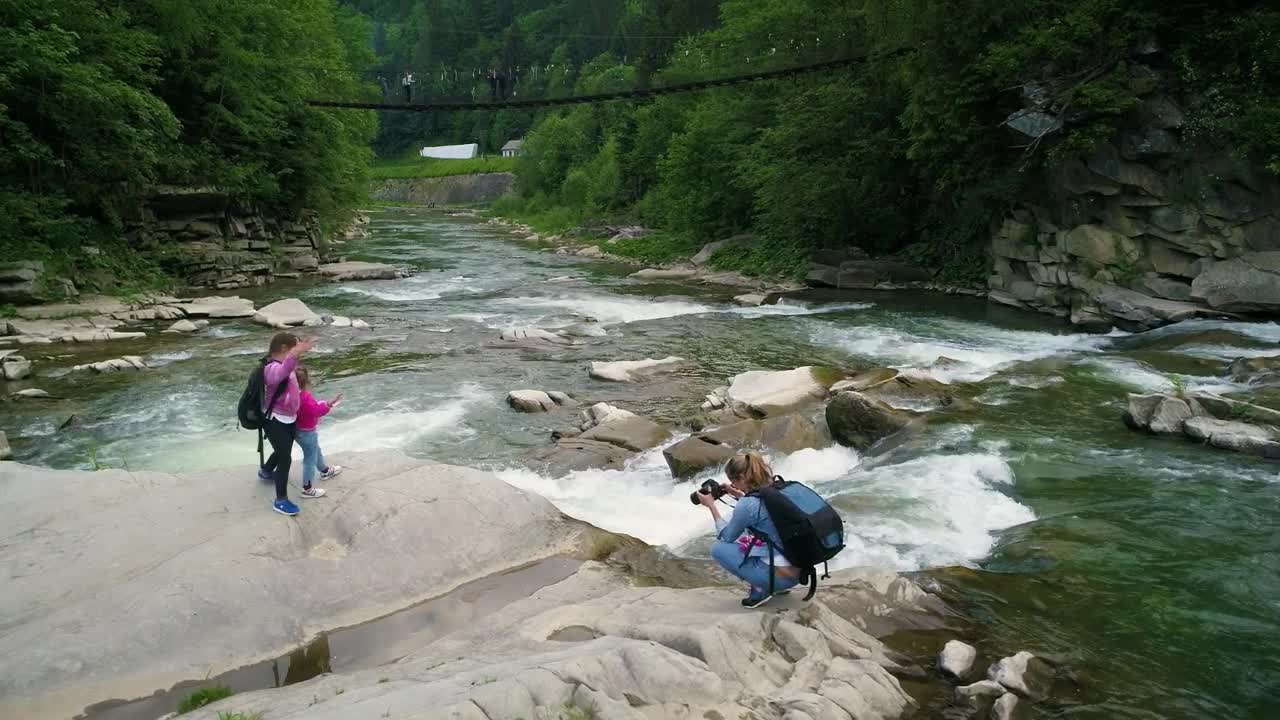 Download Stock Video Mother Taking Photos Of Her Daughters In A Rive Animated Wallpaper