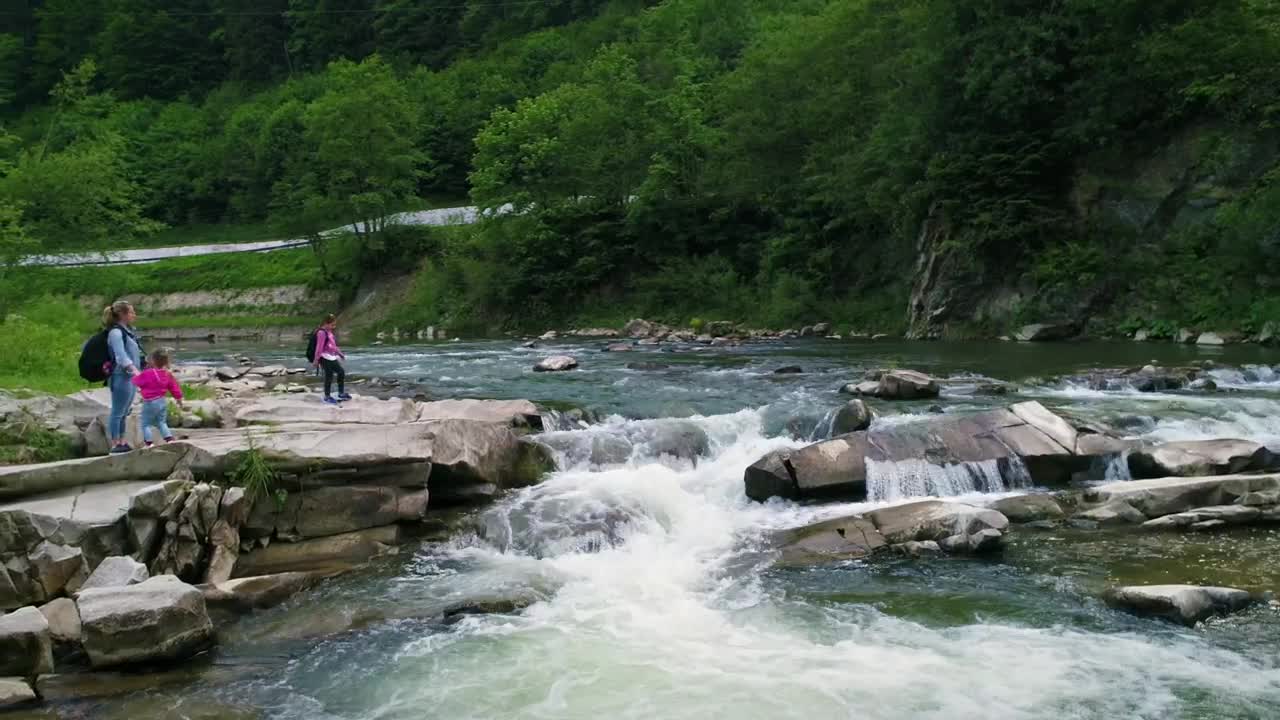 Download Stock Video Mother And Daughters Next To A River In The Fores Animated Wallpaper