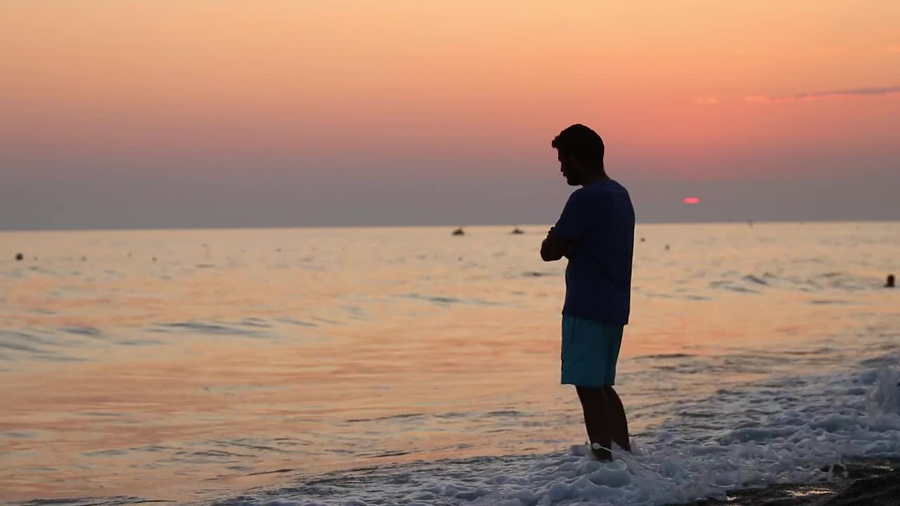 Download Stock Video Meditative Man On The Shore Of A Beach At Sunse Animated Wallpaper