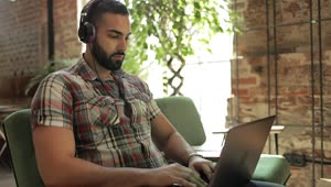Download Stock Video Man Works On Laptop With Headphones In Coworking Spac Animated Wallpaper