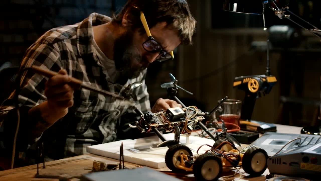 Download Stock Video Man With Glasses Soldering A Drone In The Garag Animated Wallpaper