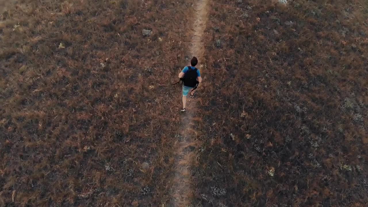 Download Stock Video Man Walking Down A Hill In An Aerial Sho Animated Wallpaper