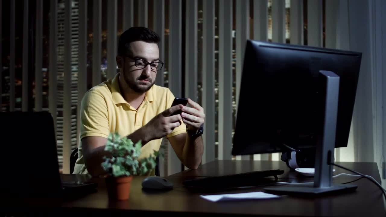 Download Stock Video Man Using His Phone At The Office At Nigh Animated Wallpaper