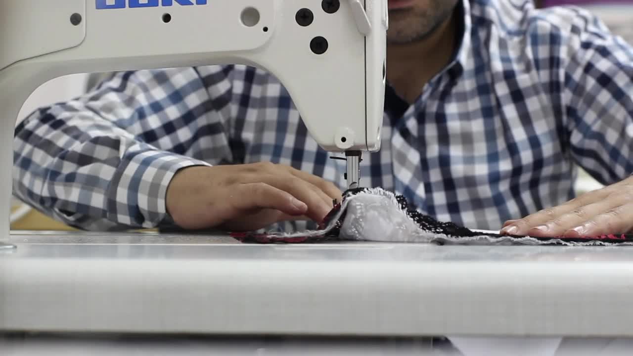 Download Stock Video Man Sewing A Garment On A Sewing Machin Animated Wallpaper